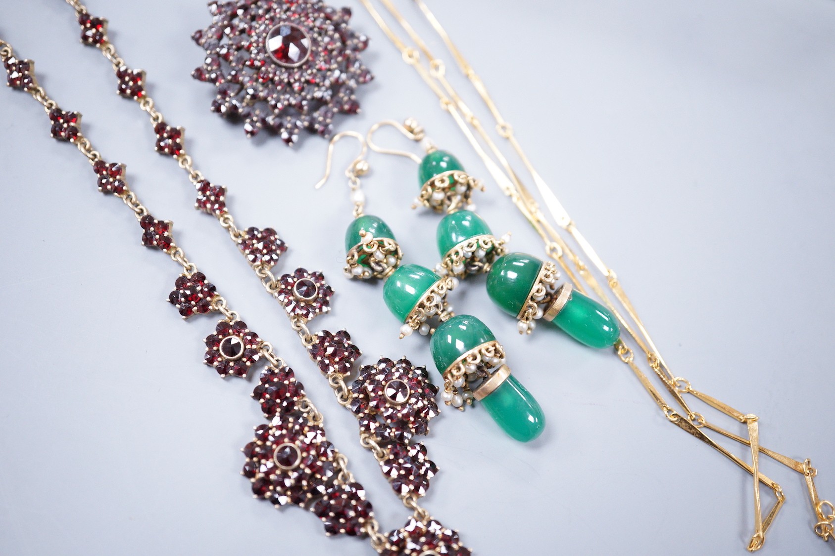 A Victorian gilt white metal and facetted garnet cluster set necklace, 42cm, a similar brooch, a pair of chrysoprase set drop earrings and a gilt metal necklace.